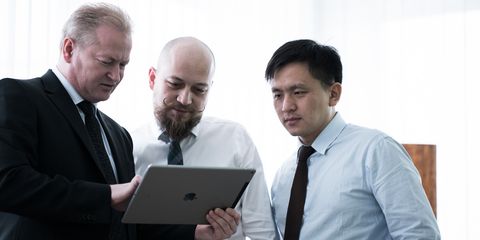drei Mitarbeiter von Häring, Projektmanager unterhalten sich mit einem Tablet in der Hand
